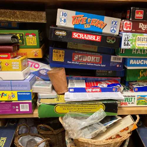 Ein Foto von vielen Brett-Spielen in einem Schrank. Der Schrank ist voll mit Spielen. Die Spiele sind bunt und verschieden.